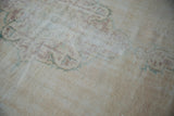 Distressed vintage Oushak carpet pile, revealing time-softened ivory, pale chestnut, and faint green.
