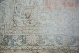 Vintage Distressed Sparta carpet close-up, floral arabesque border in dusty blush and oxidized silver blue.