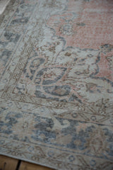 Floral arabesque and vinery on a distressed vintage Sparta carpet in dusty blush.