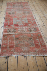 Vintage Oushak runner's distressed texture showing ruby red and oxidized silver geometric motifs.