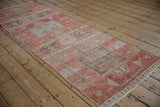Intact side cord selvage with worn cinnabar and blush geometric relief on vintage Oushak runner.