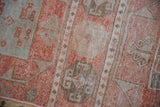 Distressed Oushak rug detail showing cinnabar, blush, beige geometric relief and pile wear.
