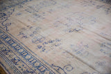 Distressed vintage Oushak with faded cobalt blue floral patterns on a pale rose ground.