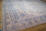 Faded cobalt blue patterns define the border of this distressed vintage Oushak rug.
