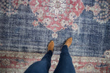 Distressed vintage Sparta rug, faded navy blue field, rich brick red medallion, ornate border.