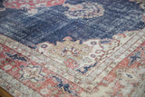 Corner of vintage Distressed Sparta Carpet showing worn navy blue field, ivory spandrel, and brick red border motifs.