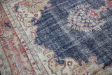 Distressed navy field and ivory spandrel with millefleur, leading to a brick red border.
