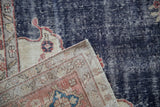 Distressed vintage Sparta rug corner showing hand knotted beige foundation and worn navy blue pile.