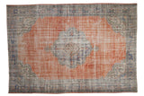 Faded terracotta distressed Oushak carpet with scalloped medallion and denim blue borders.