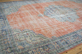 Distressed corner spandrel of vintage Oushak rug, showing denim blue and faded burnt orange.