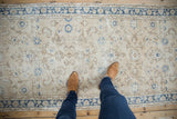 Detail of a distressed Sparta runner with antique ivory field, cobalt floral motifs, and visible pile wear.