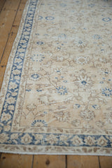 Distressed ivory Sparta runner detail: cobalt blue border, floral palmette vinery, and visible wear.