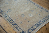 Distressed ivory field with faded cobalt blue floral vinery and palmettes.