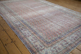 Distressed vintage Turkish Sparta carpet corner showing pale rust, indigo blue border motifs.