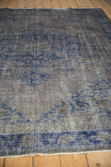 Low-pile texture of a distressed Oushak rug with oxidized silver and cobalt blue vinery.