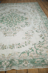 Distressed Oushak rug pile texture, revealing subtle ivory, green, and beige floral vinery.