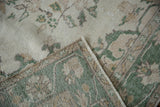 Distressed Oushak rug pile close-up in ivory, green, brown, revealing hand-knotted foundation.
