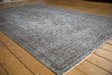 Distressed Oushak carpet showing silver and dark brown delicate buds with visible even pile wear.