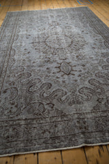 Vintage distressed Oushak carpet in oxidized silver and charcoal, revealing faded medallion and floral texture.