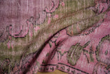 Distressed pile texture showing foundation and faded pink, mauve, olive green hues.