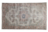 Distressed Overdyed Oushak Carpet with starburst medallion, floral sprays, in muted silver, dusty rose, blue.