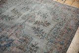 Distressed Oushak carpet pile texture, silver, dusty sandalwood, sky blue floral motifs.