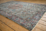 Distressed Oushak carpet corner, muted dusty terracotta, sky blue, sea foam floral patterns.