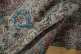 Distressed vintage Oushak carpet with worn pile, showing terracotta and sky blue floral elements.