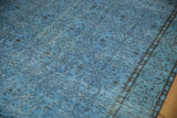 Textured distressed Turkish Oushak carpet, featuring pale denim blue and dark floral vinery.