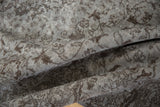 Faded silver and chocolate brown Rococo vinery on distressed vintage Oushak pile.