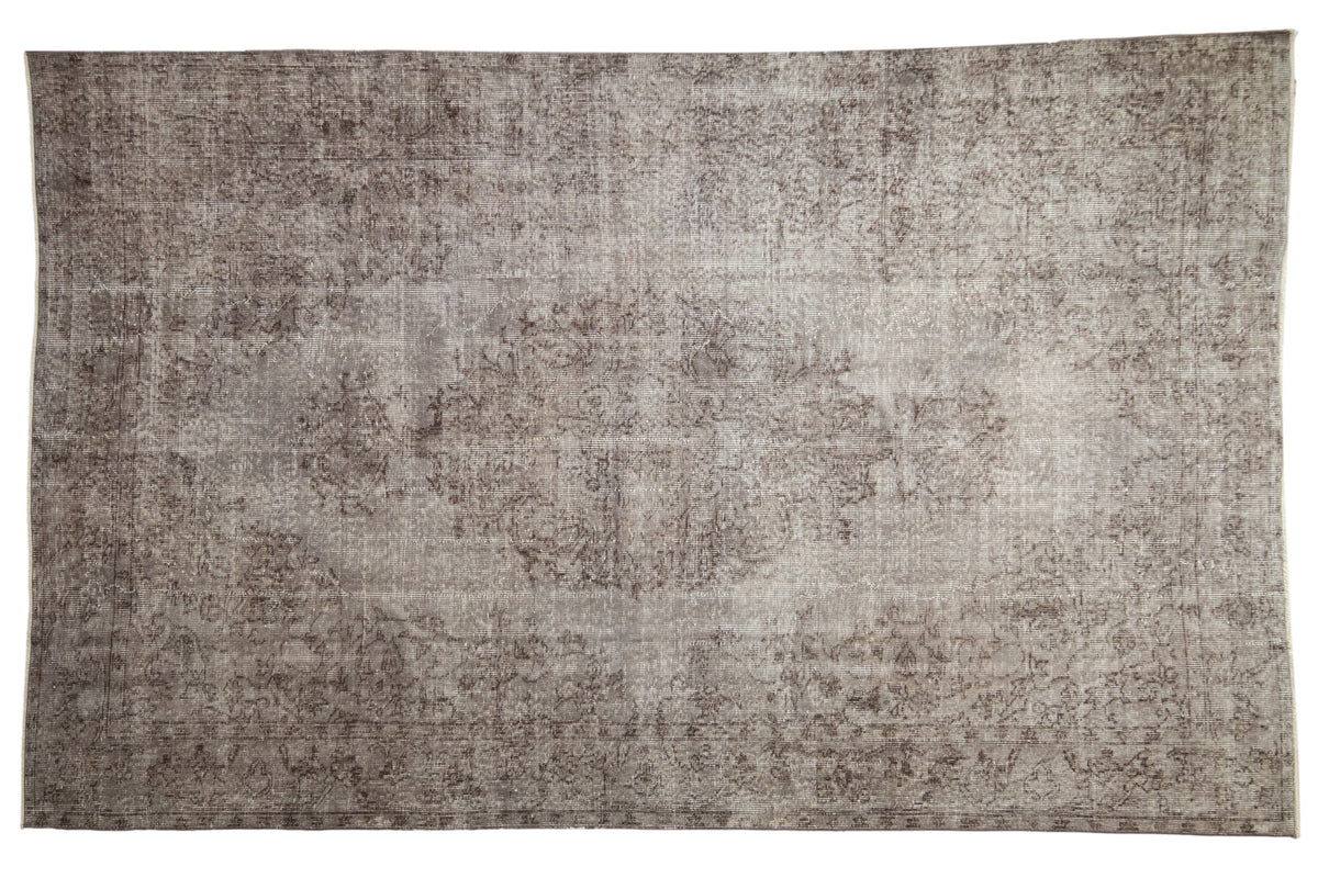 Distressed vintage Turkish Oushak carpet, faded floral medallion in silver and chocolate brown.