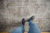 Vintage distressed Oushak carpet's time-softened silver and chocolate brown patterns underfoot.