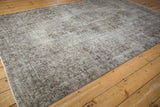 Distressed vintage Oushak rug with silver and brown time-softened ornamental design.