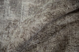 Distressed Oushak carpet close-up, showing wear to foundation in oxidized silver and chocolate brown.