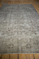 Distressed Oushak rug pile, revealing silver and chocolate floral patterns and visible foundation.