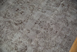 Distressed silver Oushak carpet detail: faded floral patterns, visible foundation wear.