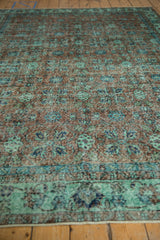 Distressed vintage Oushak carpet showing faint foundation, floral cross-sections, sea foam green.
