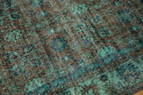 Distressed Oushak carpet's worn texture reveals faint foundation, sea foam, and cobalt blue motifs.