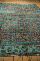 Distressed vintage Oushak rug texture with faint foundation, sea foam green and terracotta floral motifs.