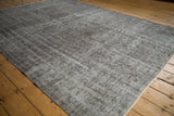 Vintage distressed Oushak carpet with muted silver and charcoal floral vinery.