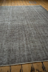 Distressed Oushak carpet showing faded silver, charcoal vinery, and varying pile texture.