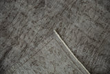 Distressed silver Oushak rug corner, showing worn pile, visible foundation, and original side selvage.