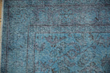 Distressed Oushak rug pile with mostly even wear, subtle florals, and varied blue tones.