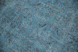 Distressed vintage Oushak rug showing denim blue field, faded Herati motif, and visible foundation.
