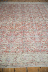 Distressed Oushak rug pile with visible foundation, showing brick red and ivory Herati design.