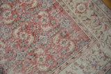 Textural detail of distressed vintage Oushak rug, brick red Herati motifs, floral border.