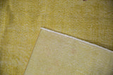 Vintage distressed Oushak rug corner, showing yellow pile with wear to knot heads and woven foundation.