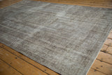 Distressed vintage Oushak rug with oxidized silver tones, showing worn texture and faded medallion.