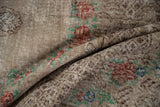 Folded Oushak carpet shows the checkered seed motif and wear down to the foundation.