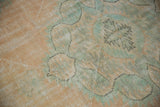 Distressed textured pile on a vintage Oushak rug, revealing peach, ivory, and pale sea foam motifs.
